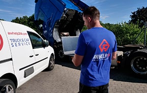 Техник AUTOWELT проверяет двигатель грузовика на обочине