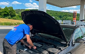 Механик AUTOWELT проверяет двигатель легкового автомобиля